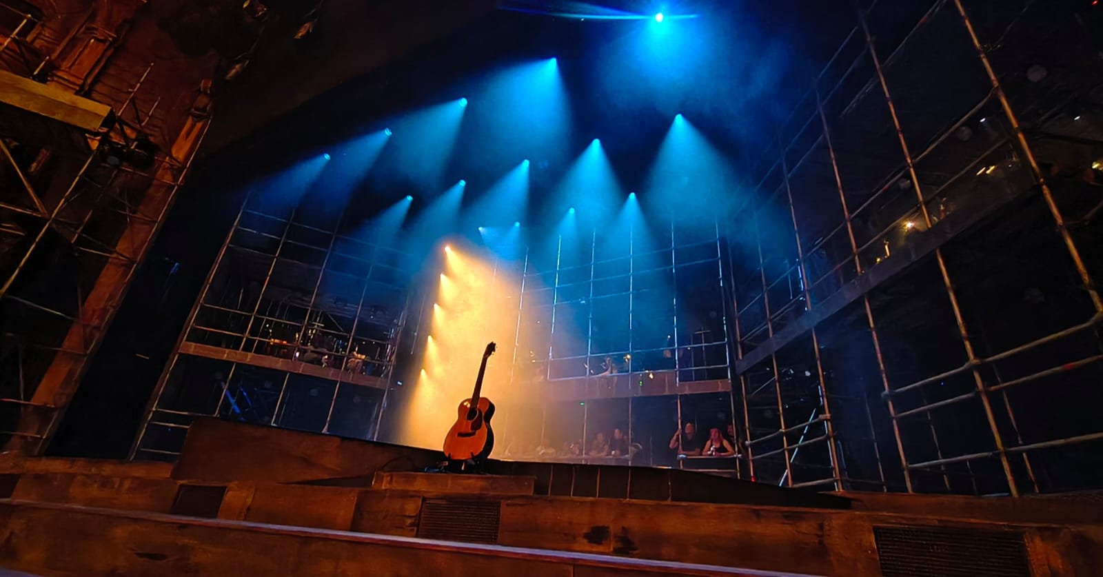 The stripped-back stage of Jesus Christ Superstar at the London Palladium, with a guitar illuminated by stage lights