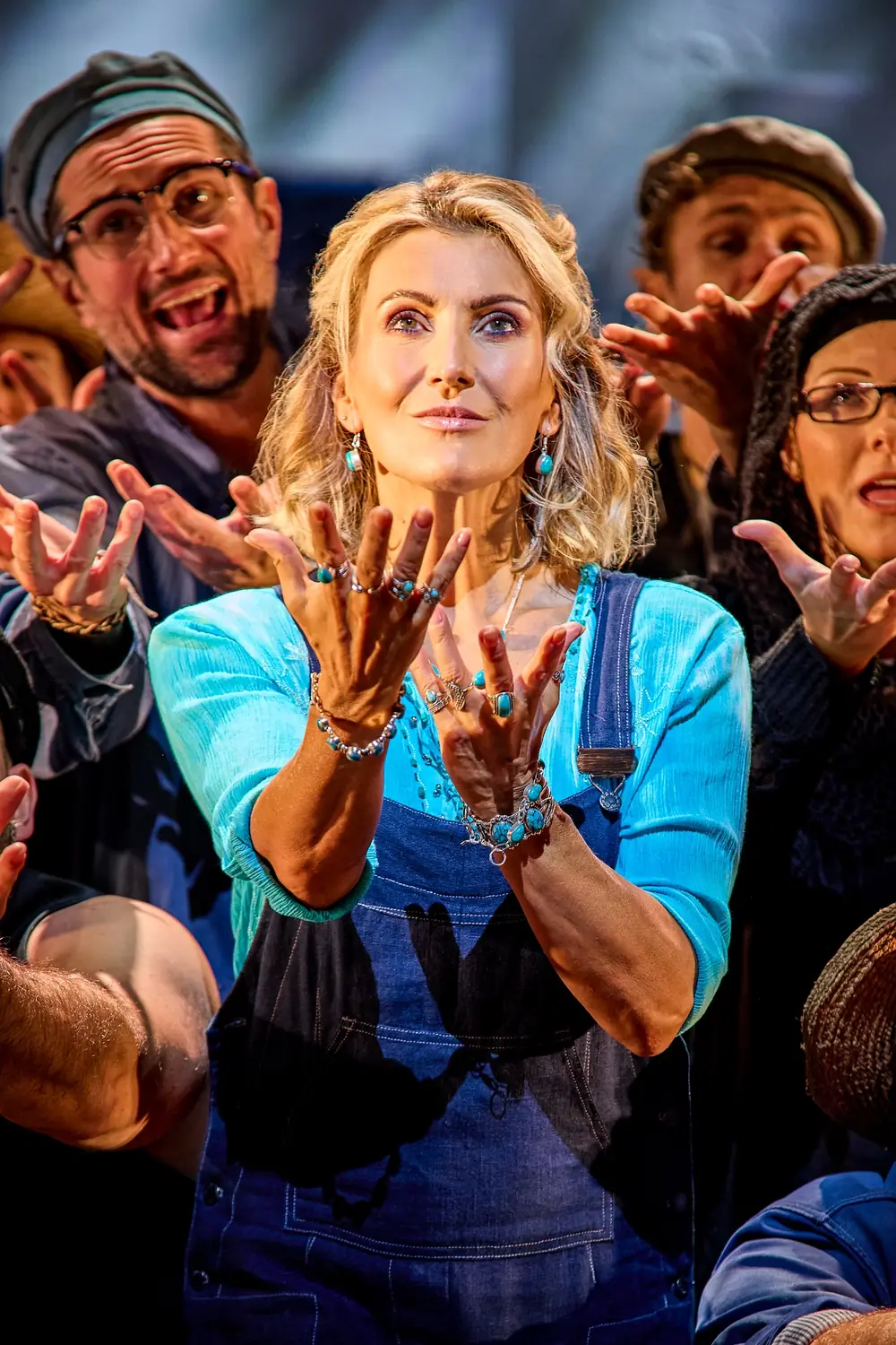 A performer in a turquoise top and denim overalls during Mamma Mia! in London's West End.