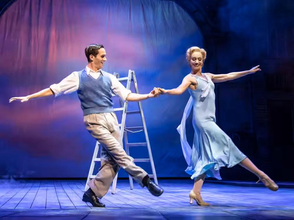 Two performers dance together on stage in Singin’ in the Rain.