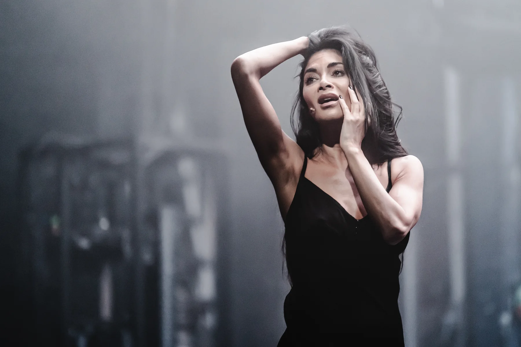 A performer in a black dress on stage in Sunset Boulevard.